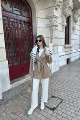 a lady wears a trench coat with white panta